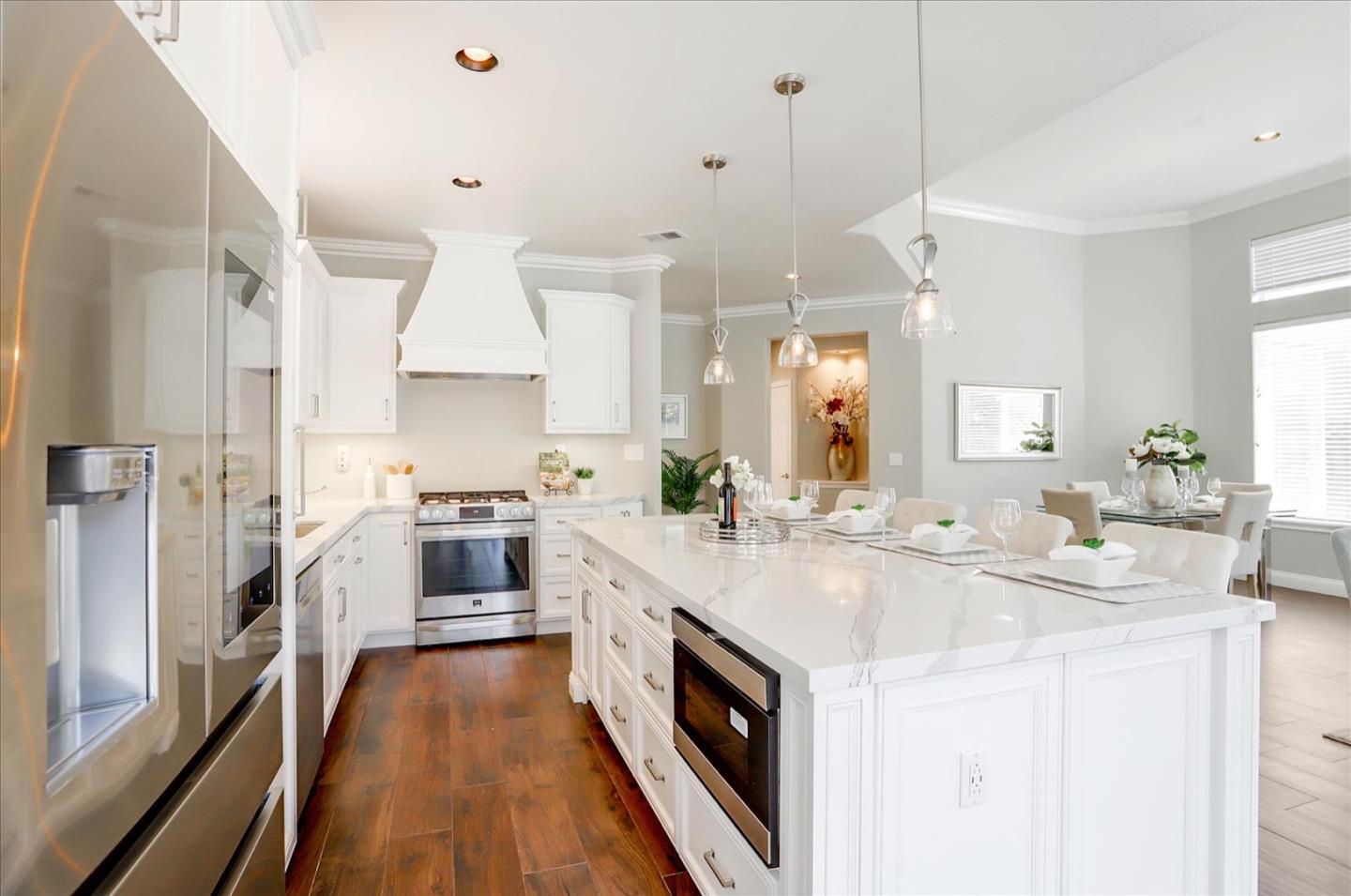 5889 Killarney Circle San Jose, CA 95138 - Photo 17 of 68 a large white kitchen with cabinets a sink a stove a refrigerator and a counter space