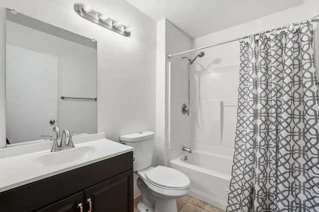 a bathroom with a sink toilet vanity and shower
