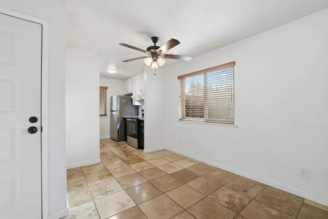 a view of a hallway with a chandelier fan and windows