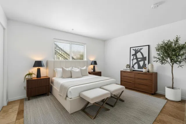 a bedroom with a bed and a painting on the wall