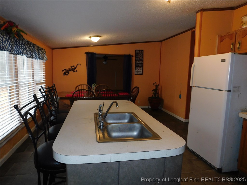 267 Ed Collins Lane Clinton, NC 28328 - Photo 16 of 45 a table with chairs a refrigerator and a stove