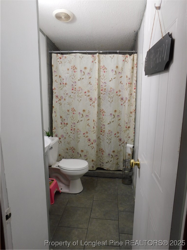 267 Ed Collins Lane Clinton, NC 28328 - Photo 22 of 45 a bathroom with a toilet and a shower curtain