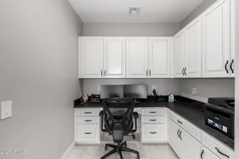 a kitchen with white cabinets and black appliances
