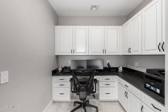 a kitchen with white cabinets and black appliances
