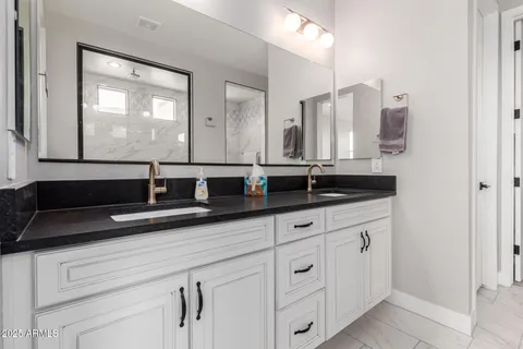 a bathroom with double sink and a mirror