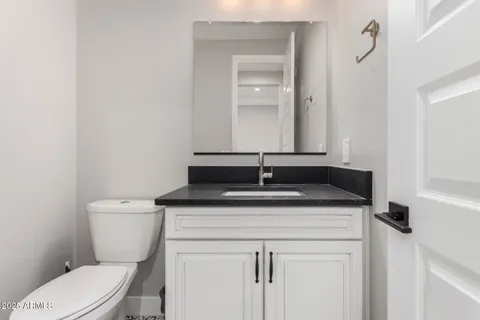 a bathroom with a granite countertop toilet sink and mirror
