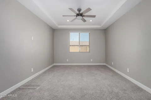 an empty room with a window and a fan