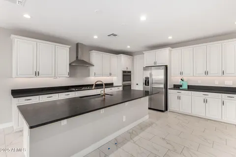 a kitchen with stainless steel appliances granite countertop a sink and a refrigerator