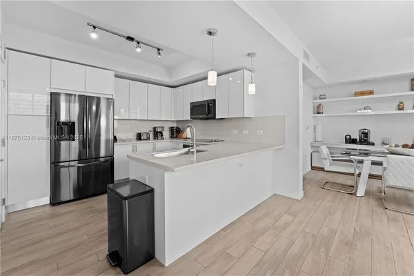 a kitchen with a refrigerator a sink and a stove top oven