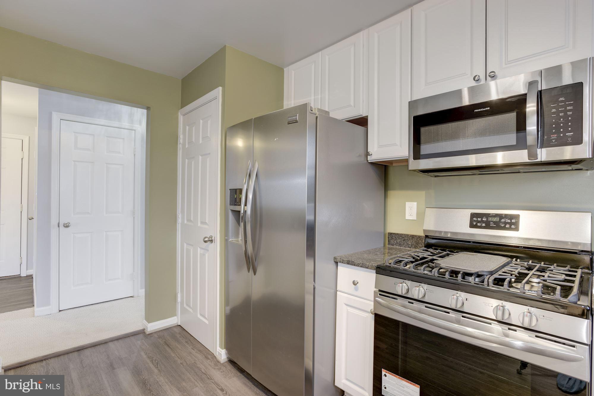 20579 Snowshoe Square, Unit 301 Ashburn, VA 20147 - Photo 13 of 30 a kitchen with stainless steel appliances a stove a microwave and a refrigerator