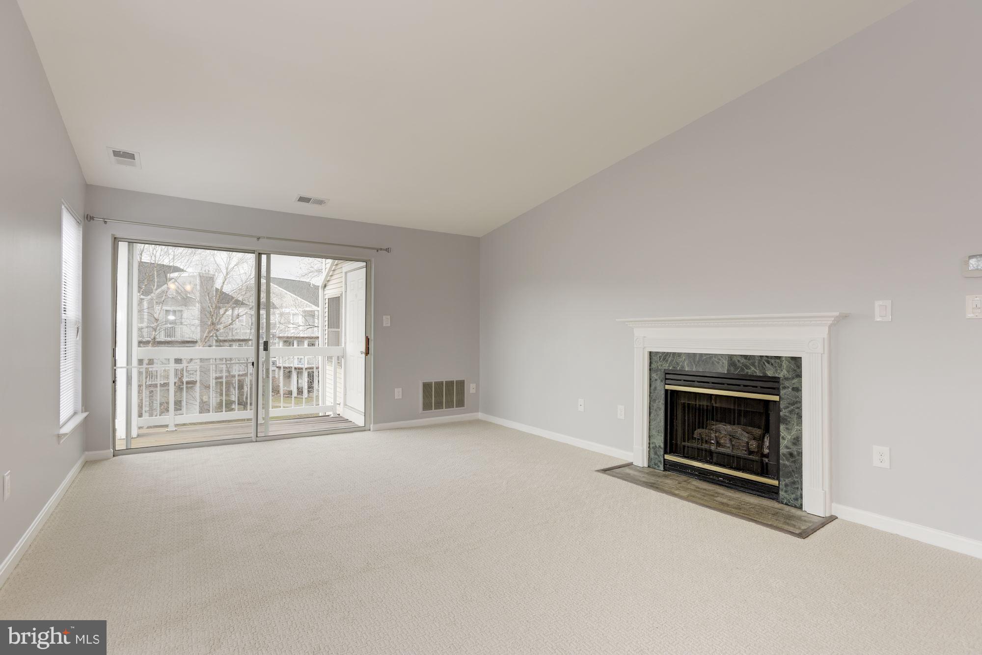 20579 Snowshoe Square, Unit 301 Ashburn, VA 20147 - Photo 7 of 30 a view of an empty room with a fireplace and a window
