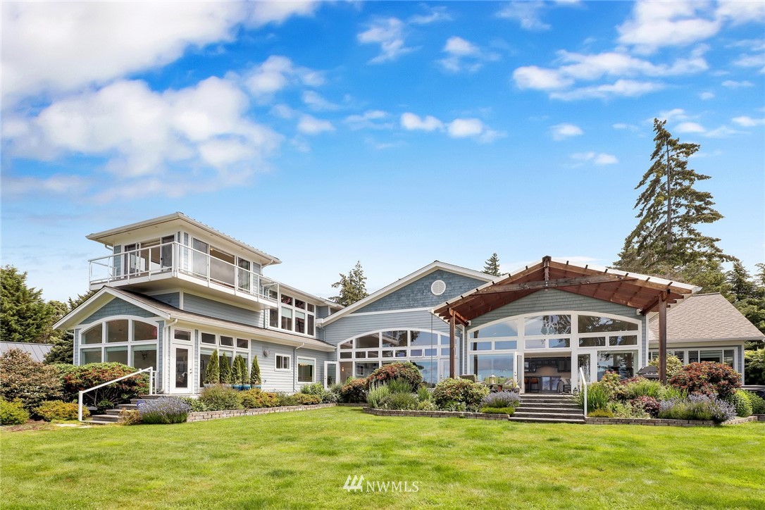 a front view of a house with a garden and trees