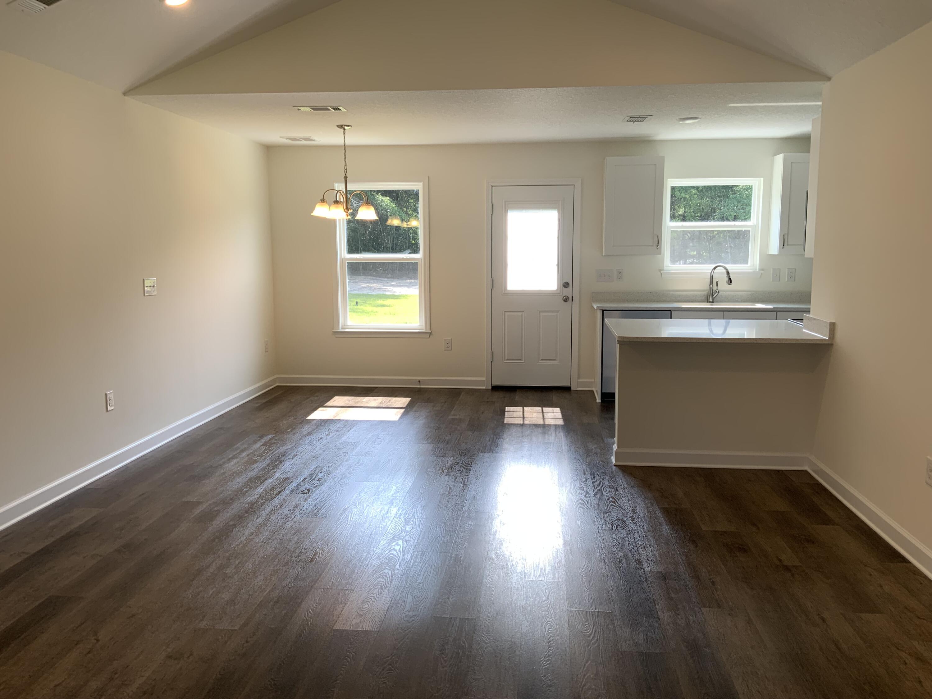 5835 Flamingo Road Crestview, FL 32539 - Photo 3 of 12 an empty room with wooden floors and windows