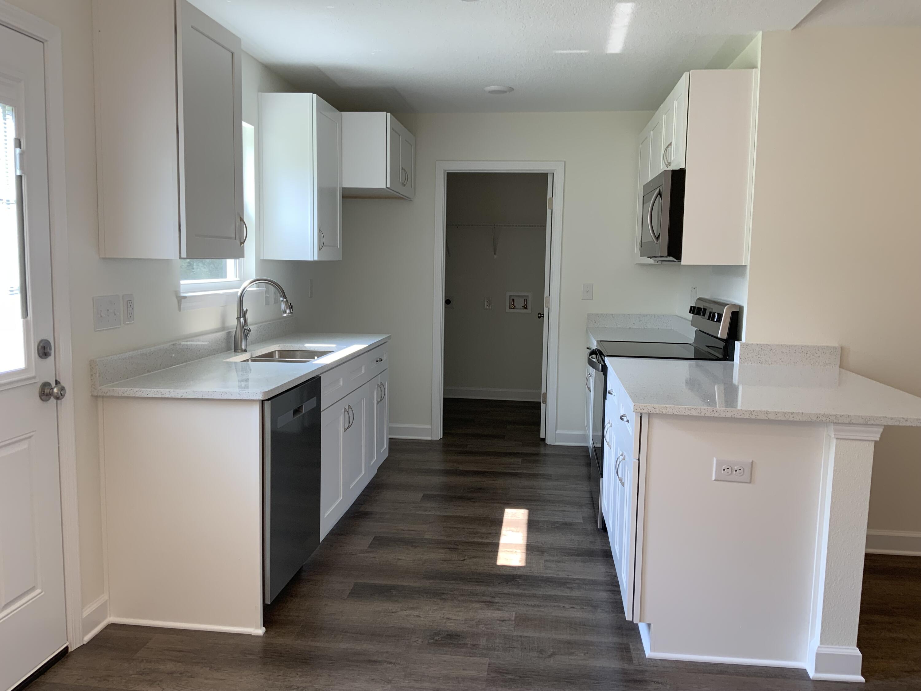 5835 Flamingo Road Crestview, FL 32539 - Photo 4 of 12 a kitchen with a sink and a wooden floor