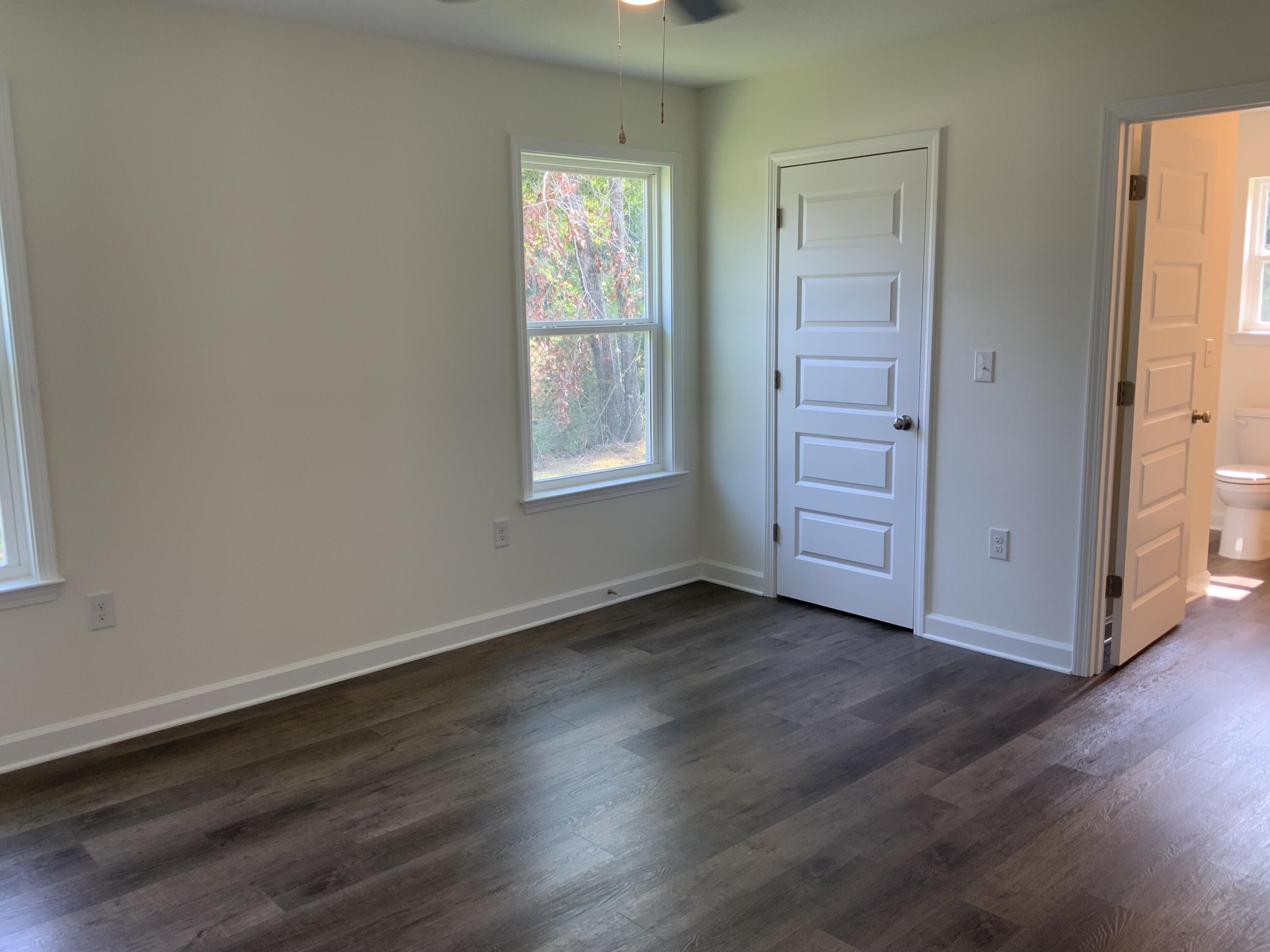 5835 Flamingo Road Crestview, FL 32539 - Photo 6 of 12 an empty room with wooden floor cabinet and windows