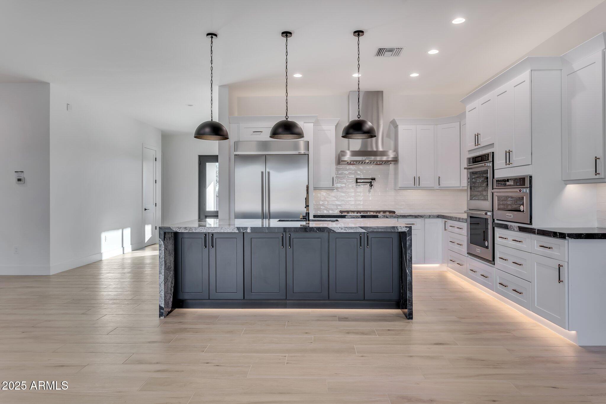 1602 East Cloud Road Phoenix, AZ 85086 - Photo 10 of 45 a large kitchen with stainless steel appliances kitchen island granite countertop a sink a stove and cabinets