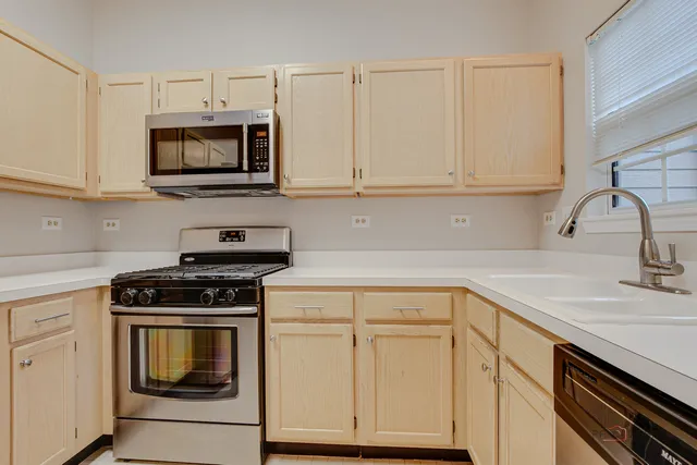 a kitchen with white cabinets and stainless steel appliances