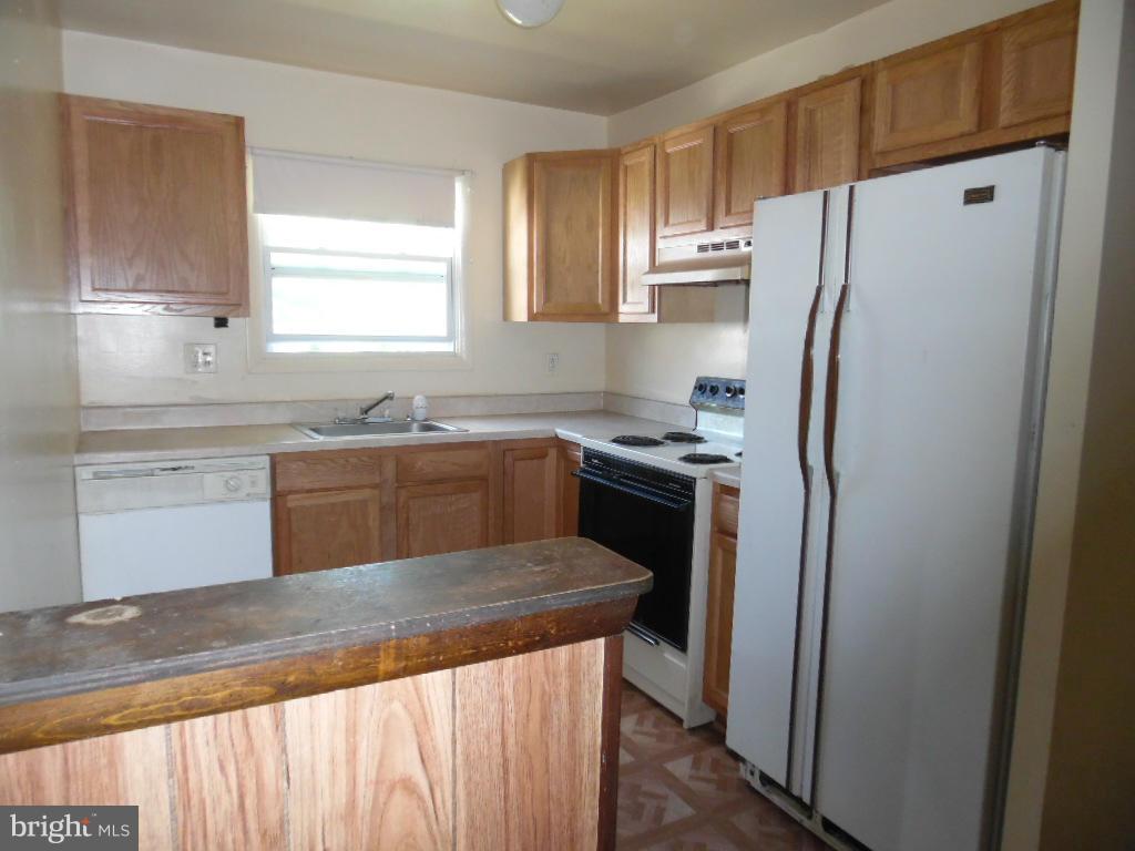 6914 German Hill Road Baltimore, MD 21222 - Photo 7 of 28 a kitchen with stainless steel appliances granite countertop a refrigerator a sink and white cabinets