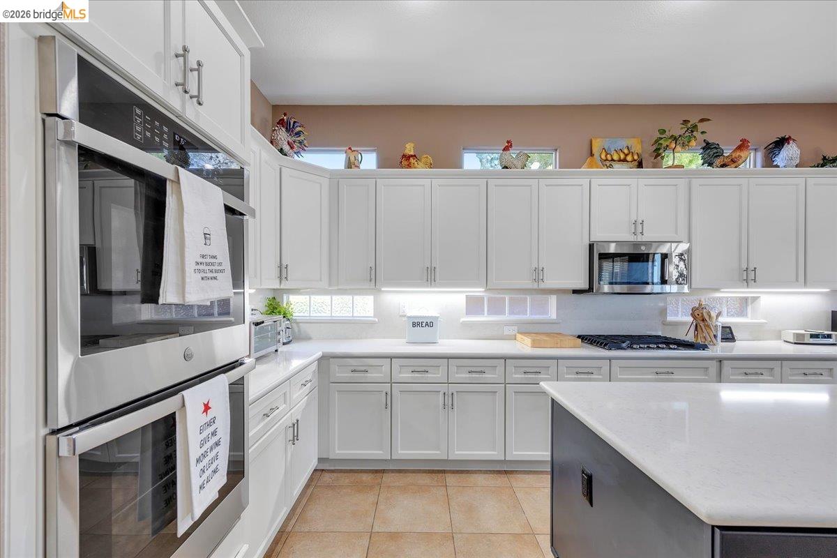 158 Rock Ridge Lane Copperopolis, CA 95228 - Photo 24 of 72 Kitchen featuring white cabinetry, stainless steel double wall ovens, a gas cooktop, and light-toned countertops