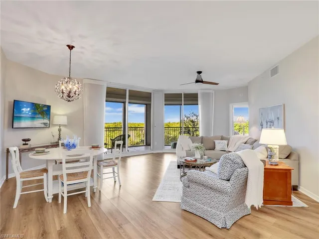 a living room with furniture dining table and a large window