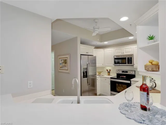 a kitchen with stainless steel appliances granite countertop a refrigerator and stove top oven