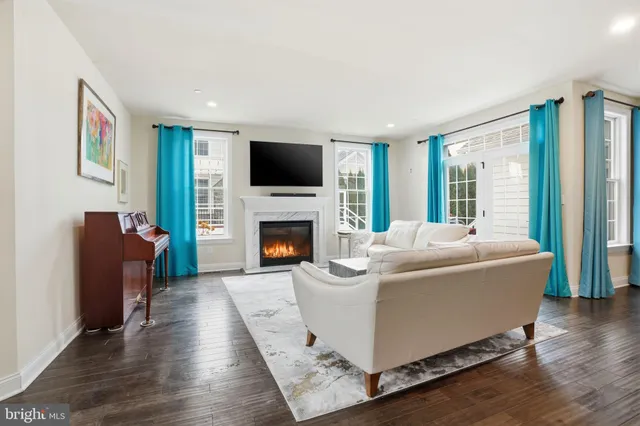 a living room with furniture a large window and a fireplace
