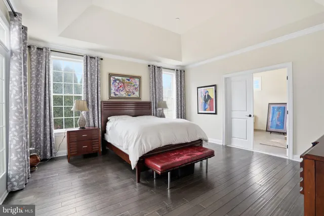 a spacious bedroom with a bed table and a window