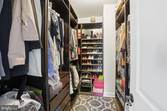 a view of walk in closet with clothes and shoes
