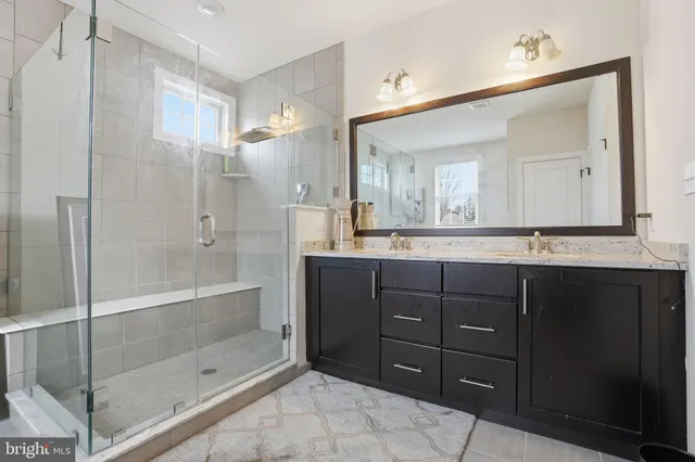 a bathroom with a shower sink and mirror