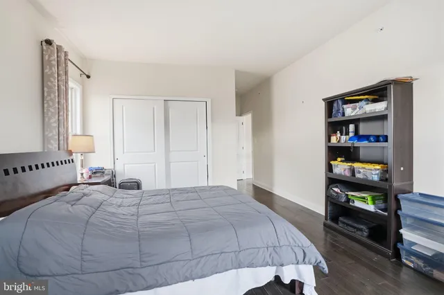 a bedroom with a bed a large window and book shelf