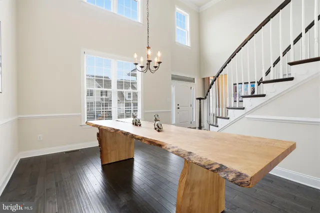 a living room with table chairs and wooden floor