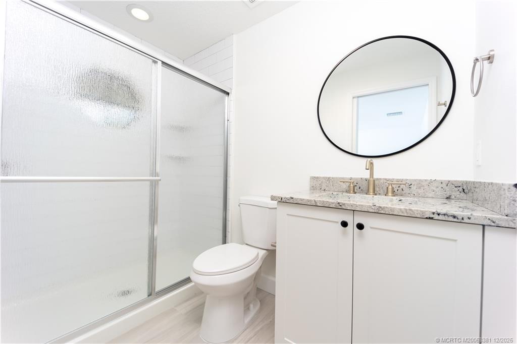 3375 Southwest Mapp Road, Unit 203 Palm City, FL 34990 - Photo 15 of 22 a bathroom with a sink a toilet and a mirror