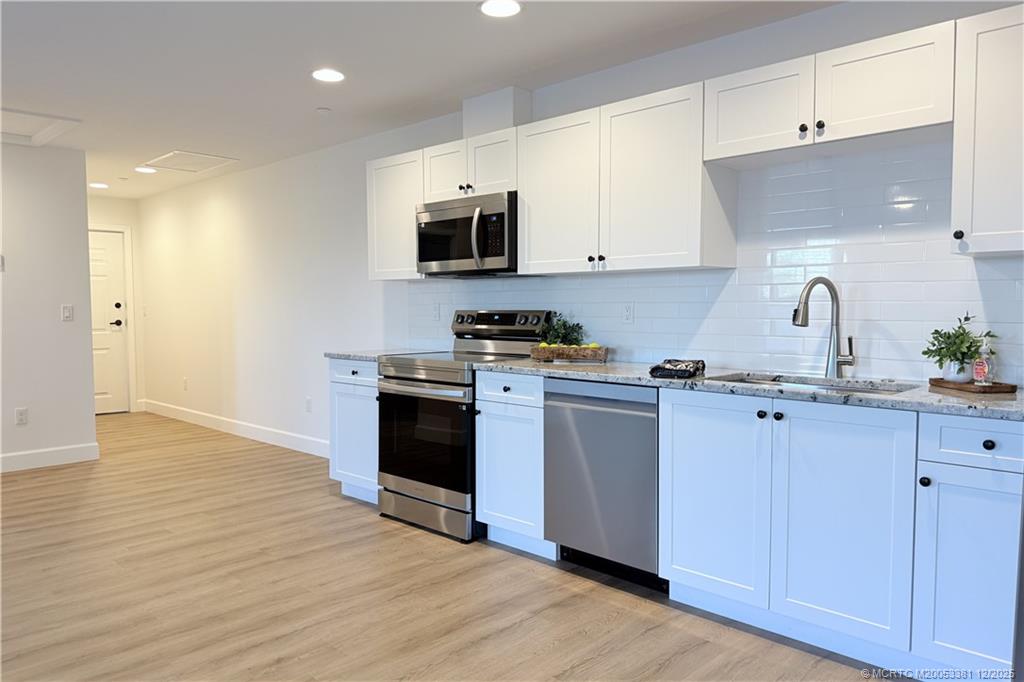 3375 Southwest Mapp Road, Unit 203 Palm City, FL 34990 - Photo 2 of 22 a kitchen with stainless steel appliances granite countertop a sink a stove a refrigerator and cabinets