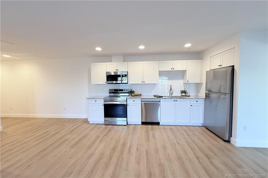 3375 Southwest Mapp Road, Unit 203 Palm City, FL 34990 - Photo 5 of 22 a kitchen with stainless steel appliances a refrigerator and a wooden floor