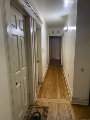 a view of a hallway with wooden floor