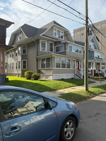 a front view of a house with garden and trees