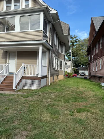 a view of a house with a yard and deck