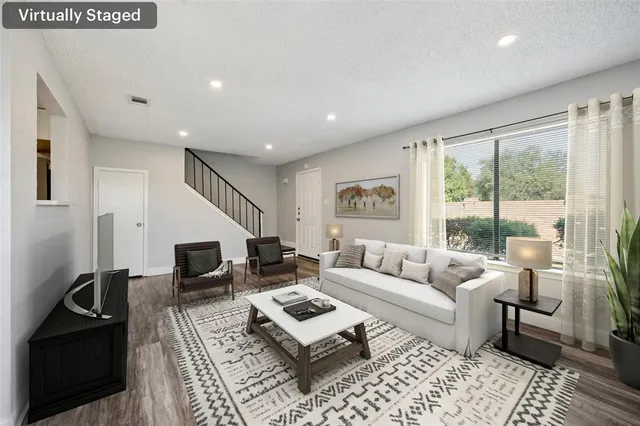 a living room with furniture rug and wooden floor