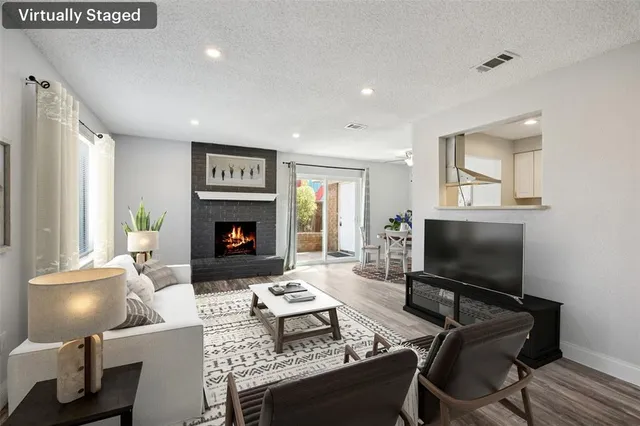 a living room with furniture a flat screen tv and a fireplace