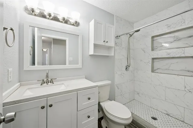 a bathroom with a sink a toilet and shower