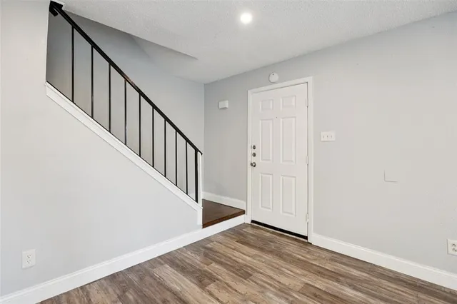 a view of a hallway with wooden floor and entryway