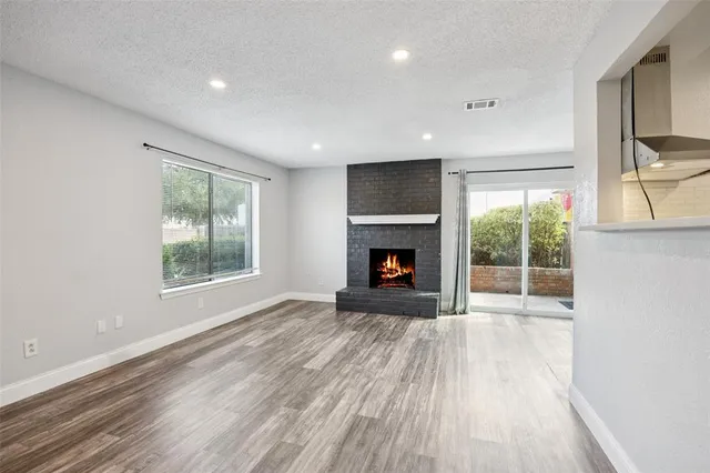 a view of empty room with wooden floor and fireplace