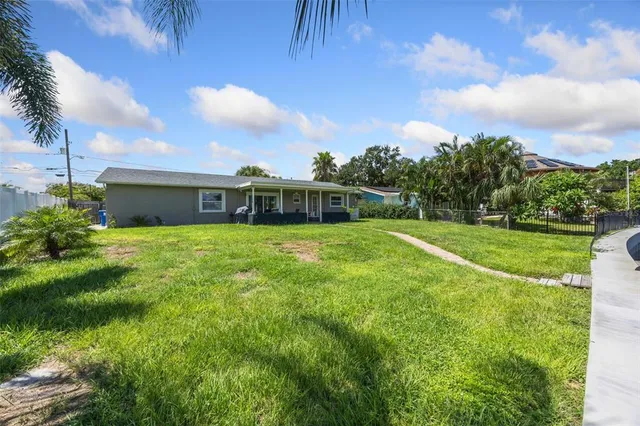 a view of a house with a swimming pool and a yard