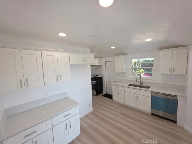 a large kitchen with a lot of counter space and wooden floor
