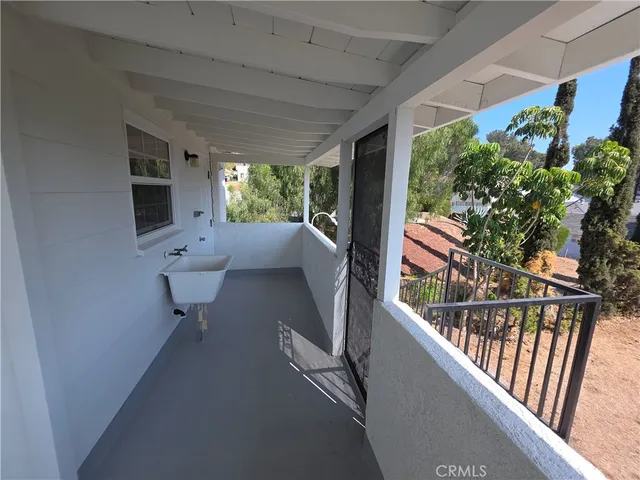 a view of a porch with furniture and a yard
