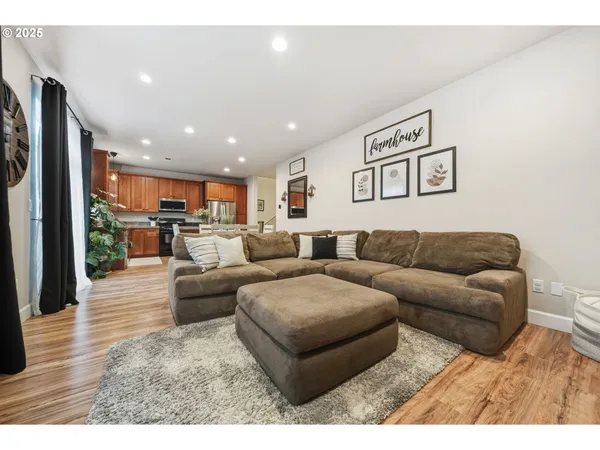 a living room with furniture and a view of kitchen