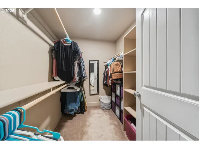 a view of walk in closet with clothes and shoes