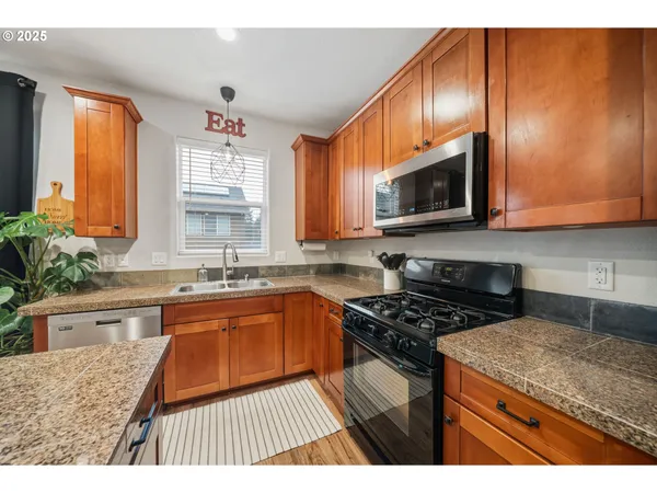 a kitchen with stainless steel appliances granite countertop wooden cabinets stove a sink and dishwasher