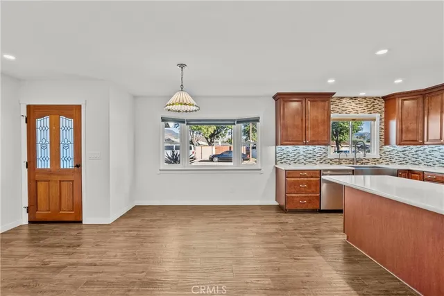 a view of large kitchen with granite countertop cabinets and window