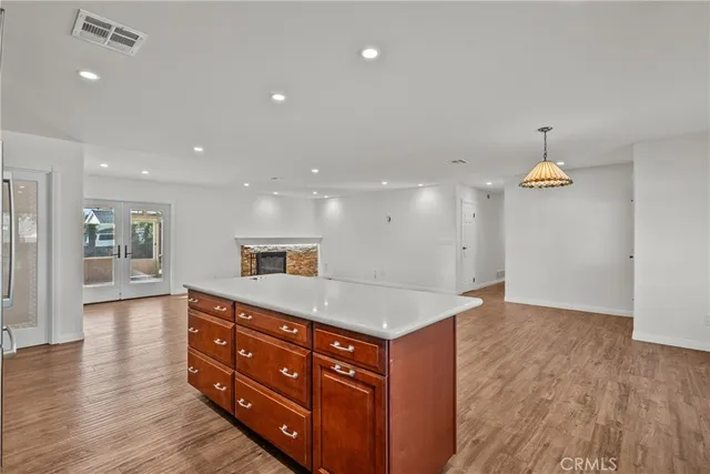 a hall with a sink a large mirror and a wooden floor